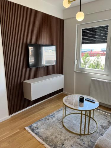 a living room with a coffee table and a tv at Green Lux Apartman Prijedor in Prijedor