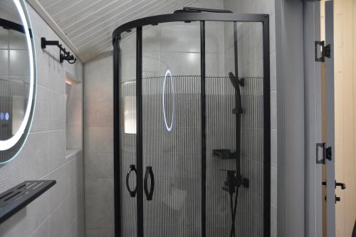 La salle de bains est pourvue d'une douche avec une porte en verre. dans l'établissement Bukovets', à Yaremtche