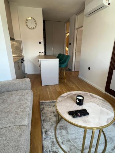 a living room with a table and a couch at Green Lux Apartman Prijedor in Prijedor
