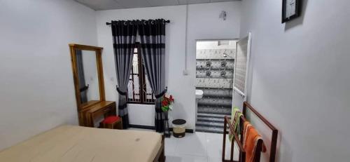a small room with a bed and a staircase at Nilaveli Guest House in Nilaveli