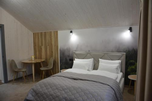 1 dormitorio con 1 cama con una pintura en la pared en Bukovets', en Yaremche