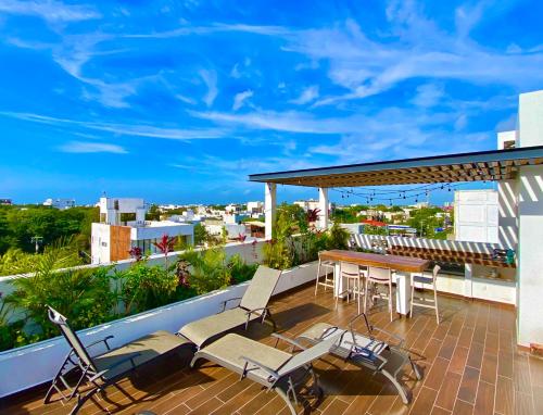 patio ze stołem i krzesłami na balkonie w obiekcie Ceiba by Andiani w mieście Playa del Carmen