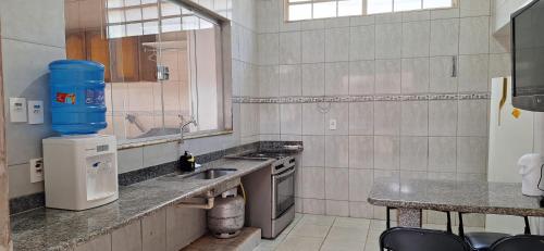 uma cozinha com um lavatório e uma bancada em Casa de Hospedagem Uberaba em Uberaba
