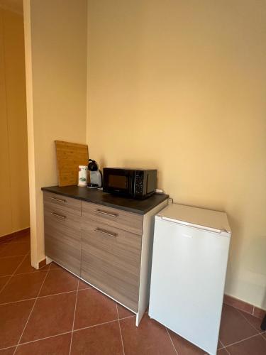a microwave sitting on top of a counter next to a refrigerator at beb Dragonara in Torremaggiore