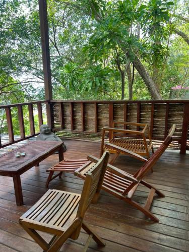 a deck with two chairs and a table and a bench at Hostel-Island Paradise, Saboga Lodge and Villa Noelia in Panama City