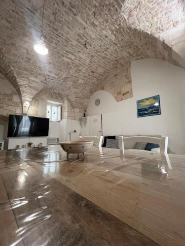 a living room with a large room with a stone wall at Al Civico 33 in Martina Franca