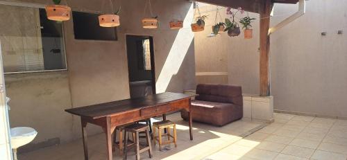 een houten tafel en een stoel in een kamer bij Casa de Hospedagem Uberaba in Uberaba