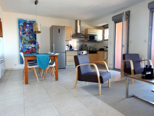 eine Küche und ein Wohnzimmer mit einem Tisch und Stühlen in der Unterkunft Appartement avec vue exceptionnelle sur mer in Cerbère