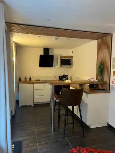 une cuisine avec une table et des chaises dans une pièce dans l'établissement Love room: Aux plaisirs des sens jacuzzi privé, à Barr