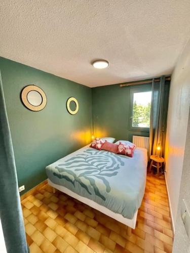 - une chambre avec un lit dans un mur vert dans l'établissement Le Nid Ensoleillé - Centre port, au Cap d'Agde