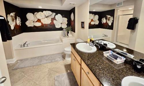 La salle de bains est pourvue de 2 lavabos et d'une baignoire. dans l'établissement Seaside Treasure, à Biloxi