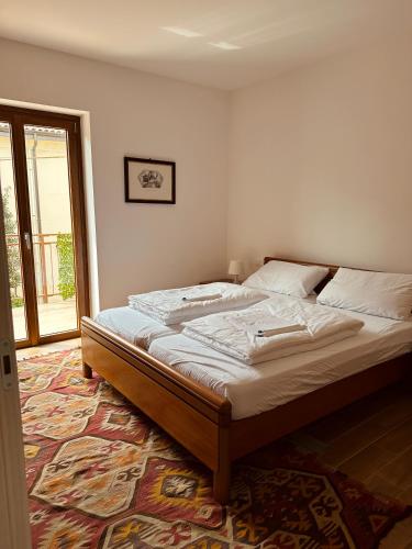 Cette chambre comprend un grand lit et une fenêtre. dans l'établissement Apartment Adriana, à Muggia