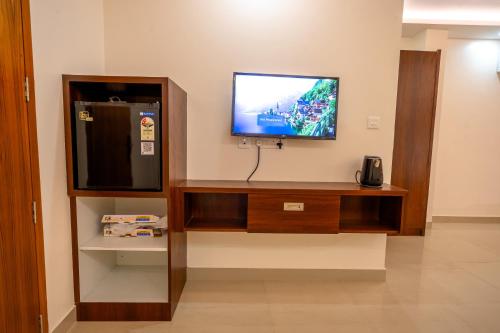 a flat screen tv sitting on top of a wall at Metro Residency in Tirūr