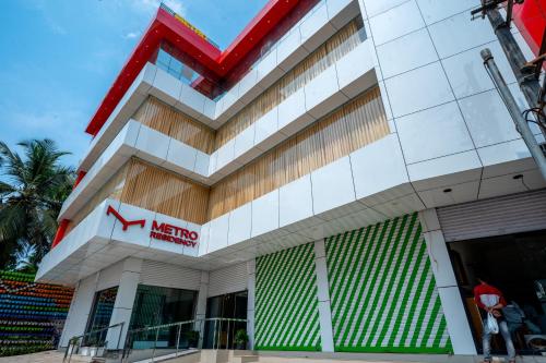 a building with a krispy kreme sign on it at Metro Residency in Tirūr