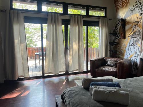 a living room with a couch and large windows at Hostel-Island Paradise, Saboga Lodge and Villa Noelia in Panama City