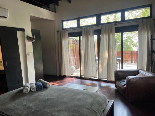 a bedroom with a bed and a couch and windows at Hostel-Island Paradise, Saboga Lodge and Villa Noelia in Panama City