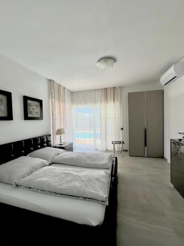 a bedroom with two beds and a large window at Villa Anna in Premantura