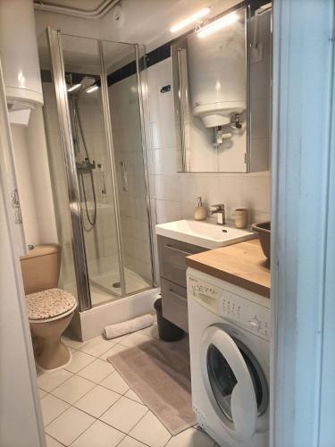 une salle de bain avec douche et machine à laver dans l'établissement Studio cosy CLIMATISE vue mer Canet Plage 3étoiles, à Canet