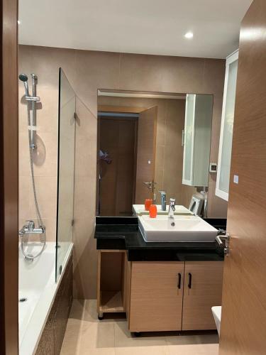 une salle de bain avec un lavabo, un miroir et une douche dans l'établissement Plage des nations, à Sale