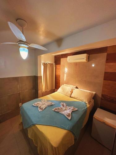 a bedroom with a bed with towels on it at Mata Virgem Hostel e Pousada in Abraão