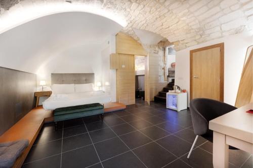 een slaapkamer met een bed en een bank in een kamer bij Itria Palace in Ragusa