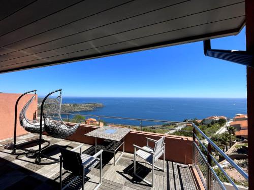 a balcony with a table and chairs and the ocean at Appartement avec vue exceptionnelle sur mer in Cerbère