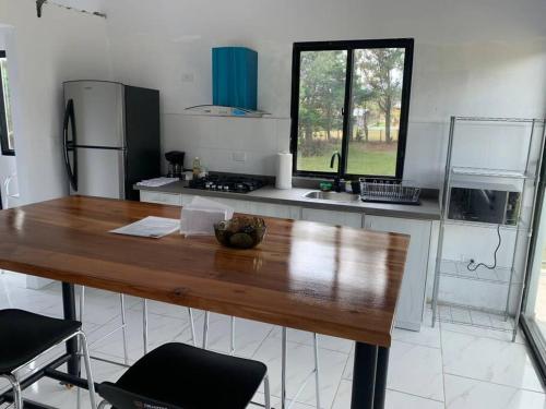 a kitchen with a wooden table and a counter top at Acogedor apartamento con hermosa vista al volcán - The Goat Spot - planta alta in Alto Boquete