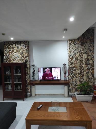 a living room with a tv on a stone wall at Oceanida Bay Hotel in Pythagoreio
