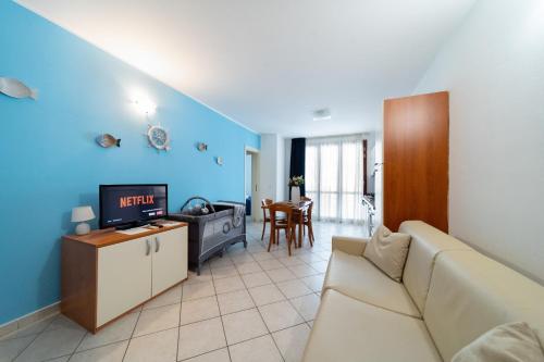 a living room with a couch and a tv at Residence Alessandra in Cesenatico