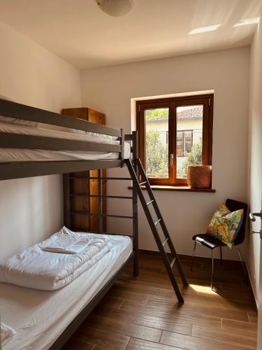 a bedroom with a bunk bed and a chair at Apartment Adriana in Muggia