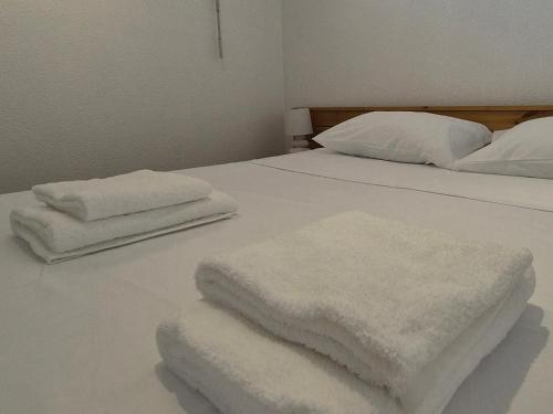 - un lit blanc avec 2 serviettes blanches dans l'établissement Superbe T2 - 200m de la mer - Piscine - Parking, à Villeneuve-Loubet