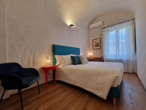 a bedroom with a bed and a chair and a window at Lo Strullo in Pisa