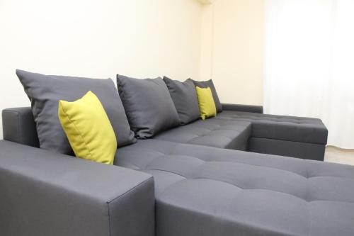 a gray couch with two yellow pillows on it at Haris Studio 2 in Keramotí