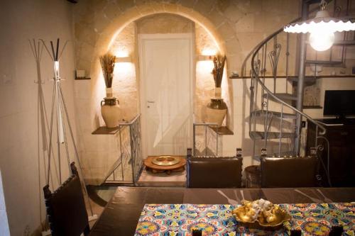 Casa Masiello La casa tipica dei Sassi di Matera في ماتيرا: غرفة طعام مع طاولة وغرفة مع باب