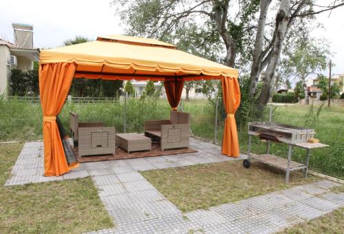 an orange gazebo with boxes and a grill at Haris Studio 2 in Keramotí