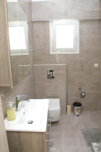 a bathroom with a white sink and a toilet at Haris Studio 2 in Keramotí