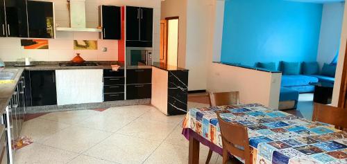 a kitchen with a table and a blue couch at Vivre un experience inoubliable in Casablanca