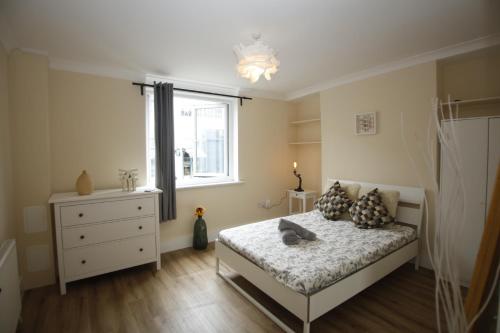 a bedroom with a bed and a window at COSY CAMDEN 2 BEDROOM APARTMENT WITH TERRACE in London