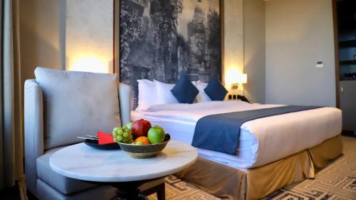 a hotel room with a bed and a bowl of fruit on a table at Five Seasons Hotel in Tabuk