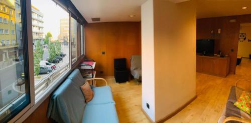 uma sala de estar com um sofá e uma grande janela em Corujinha Hostel em Lisboa