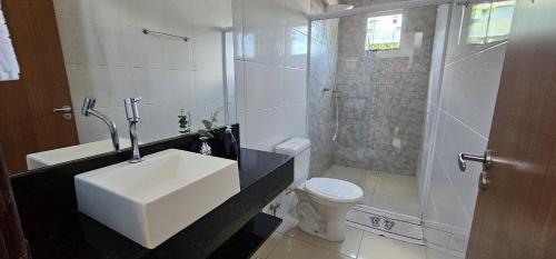 een badkamer met een wastafel, een douche en een toilet bij Casa Duplex Alegria - Ar e Garagem Privativa in Bom Jesus da Lapa