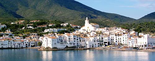 a group of white buildings on the shore of a body of water at Appartement avec vue exceptionnelle sur mer in Cerbère