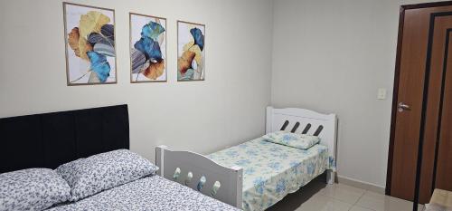 een slaapkamer met 2 bedden en foto's aan de muur bij Casa Duplex Alegria - Ar e Garagem Privativa in Bom Jesus da Lapa