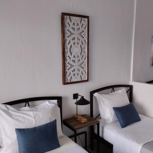 a room with two beds and a picture on the wall at Thanos ,Rooms and Apartments in Ouranoupoli