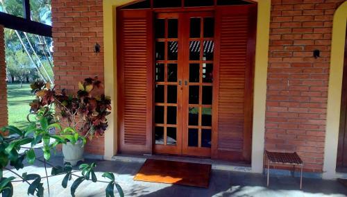 a red door on a brick building with a plant at Chácara em Boituva com piscina e churrasqueira in Boituva