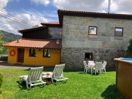 ギマランイスにあるBergui Guesthouse - Em Guimarães desde 2017の椅子とテーブルのある庭と家