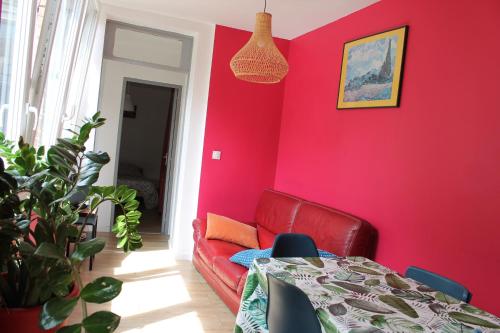 une chambre rouge avec une table et un canapé rouge dans l'établissement APPARTEMENT CENTRE HISTORIQUE, à Besançon