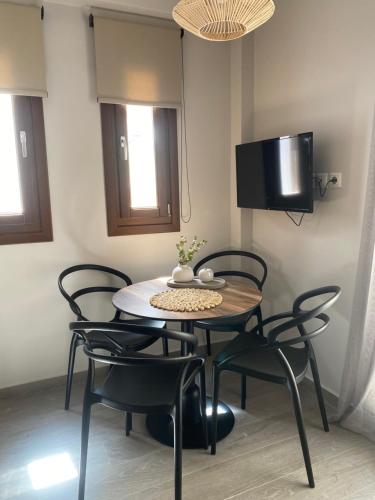 a dining room with a table and chairs and a tv at Αura Luxury Apartments in Ierissos