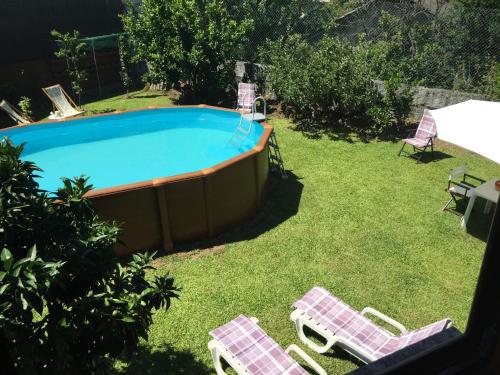 een zwembad met 2 ligstoelen en een tafel bij Bergui Guesthouse - Em Guimarães desde 2017 in Guimarães