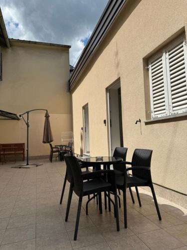 a patio with chairs and a table and a umbrella at Apartments Ascic in Opatija